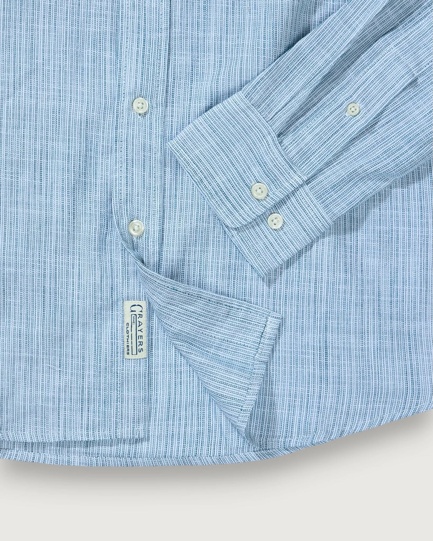 Close-up of a light blue striped shirt with a collar and pocket on a white background