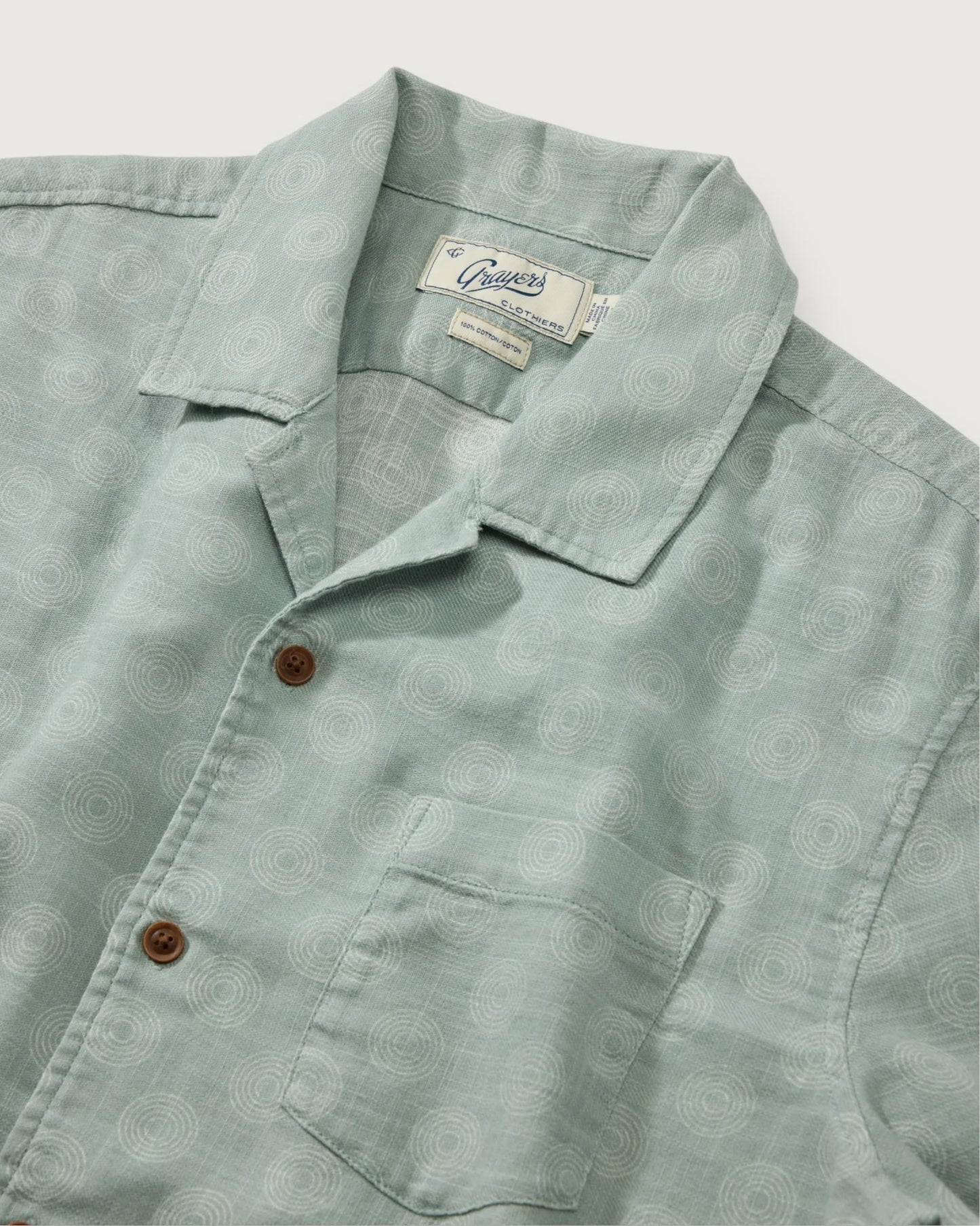 Light green shirt with collar and buttons on a light gray background