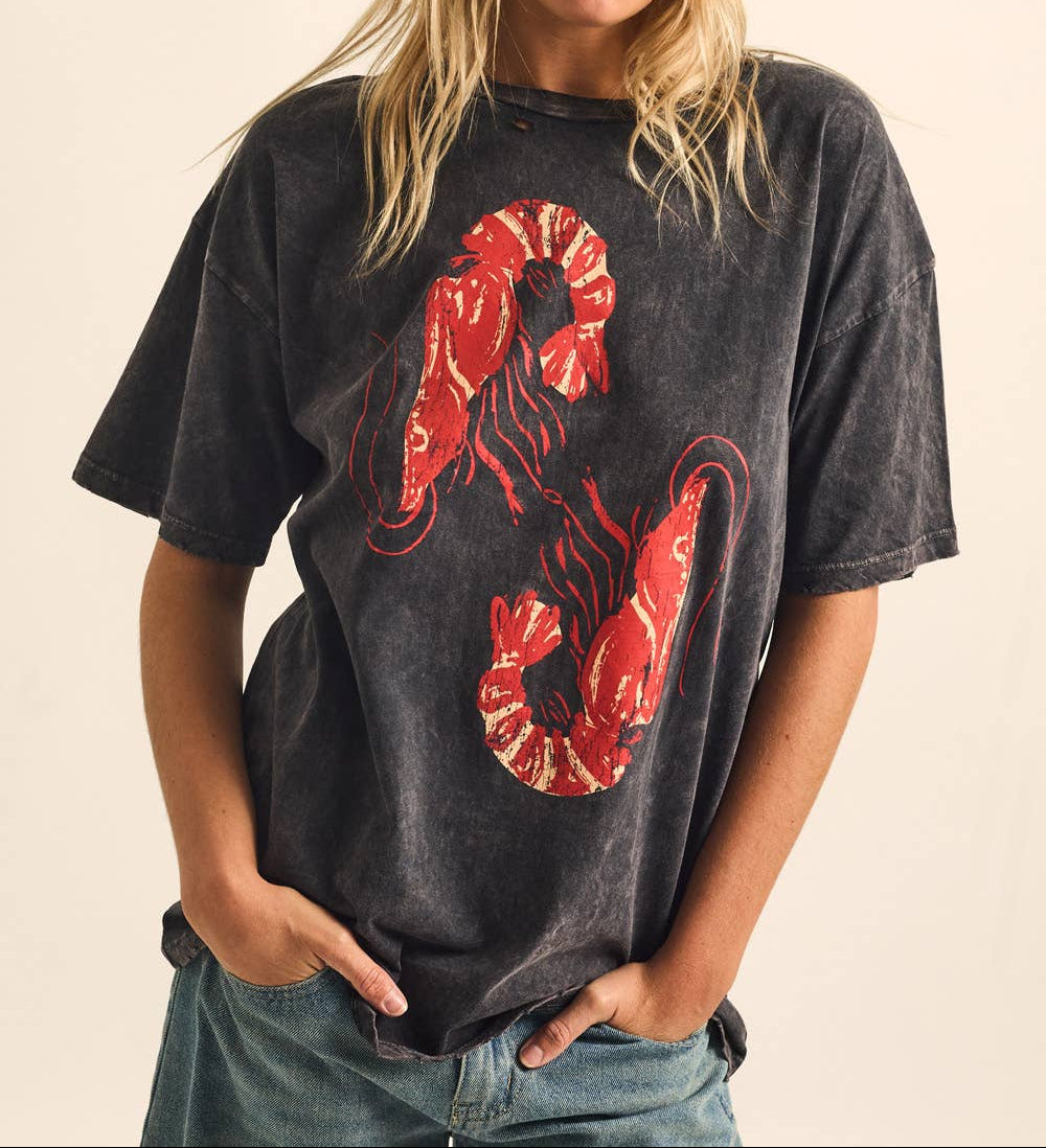 Woman wearing a black t-shirt with a red snake design on a beige background