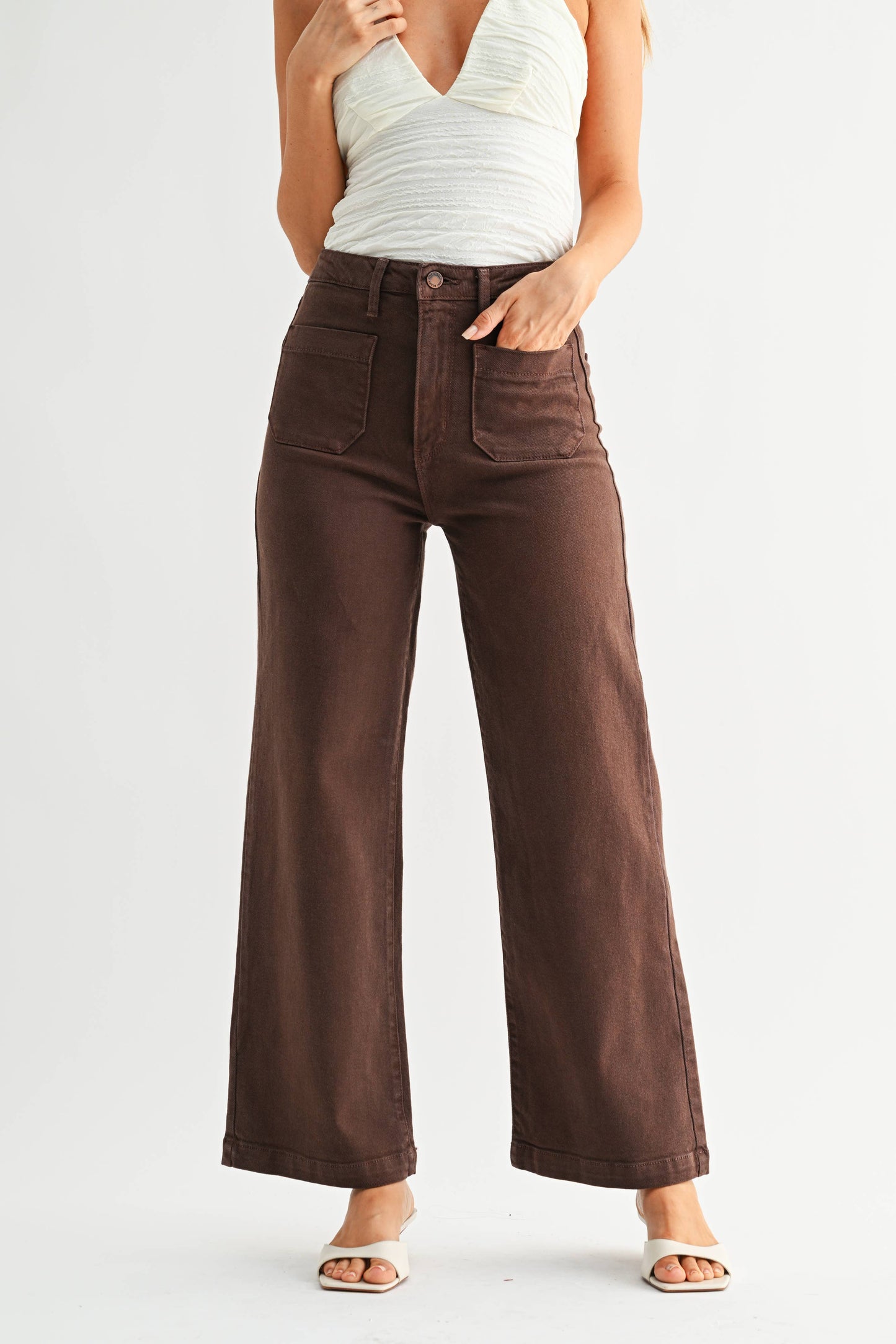 Brown wide-leg jeans worn by a person on a plain background