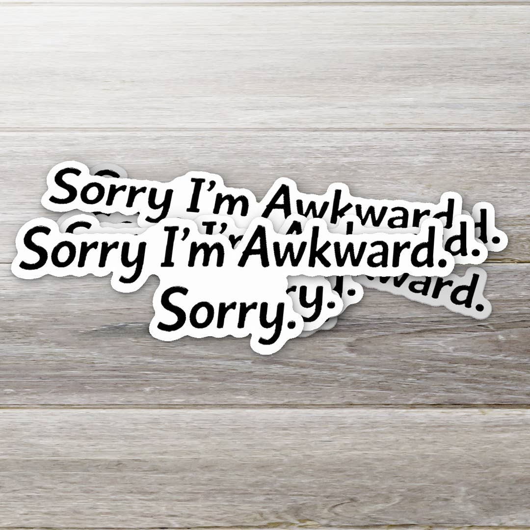 Multiple 'Sorry I'm Awkward' stickers on a wooden surface