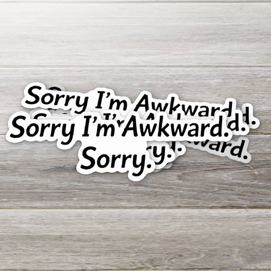 Multiple 'Sorry I'm Awkward' stickers on a wooden surface