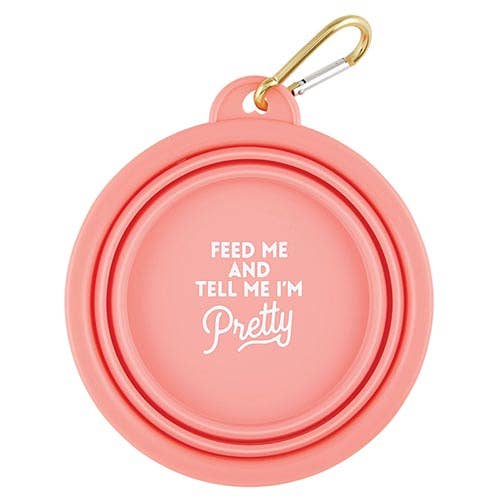 Pink pet bowl with 'Feed me and tell me I'm pretty' text and gold carabiner on a white background