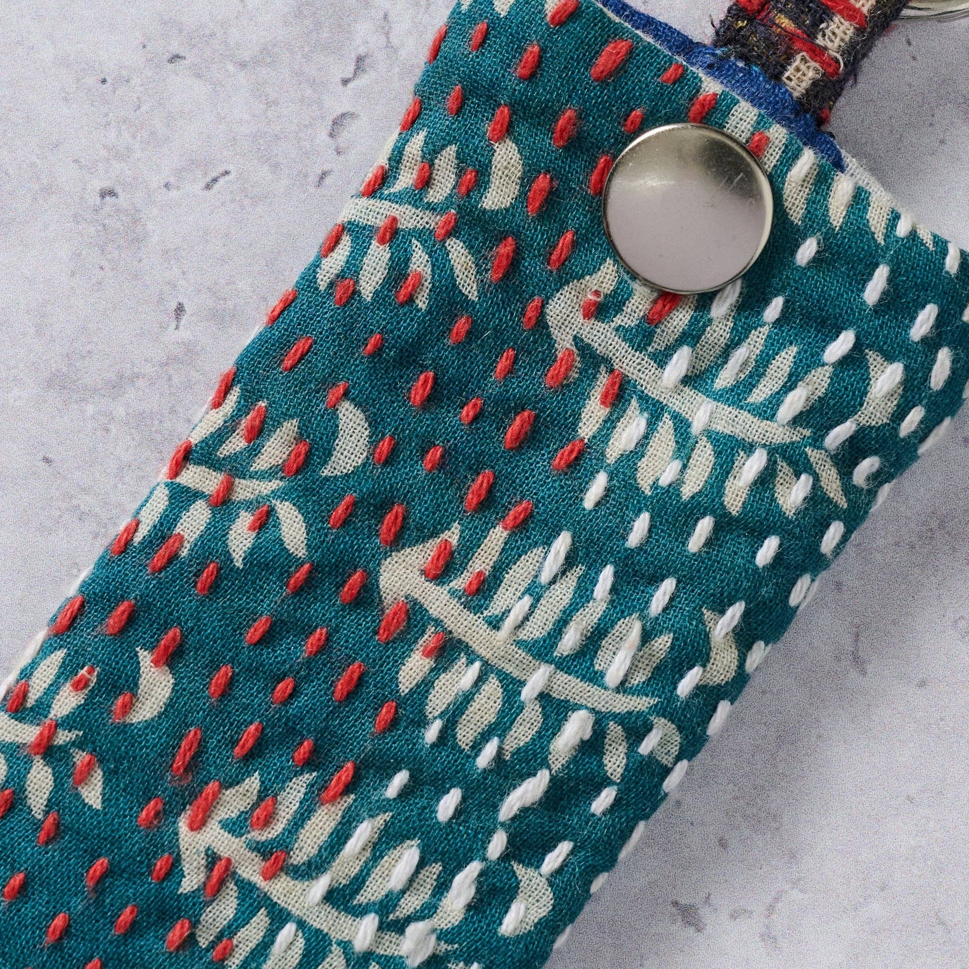 Fabric pouch with red and white pattern on a gray surface