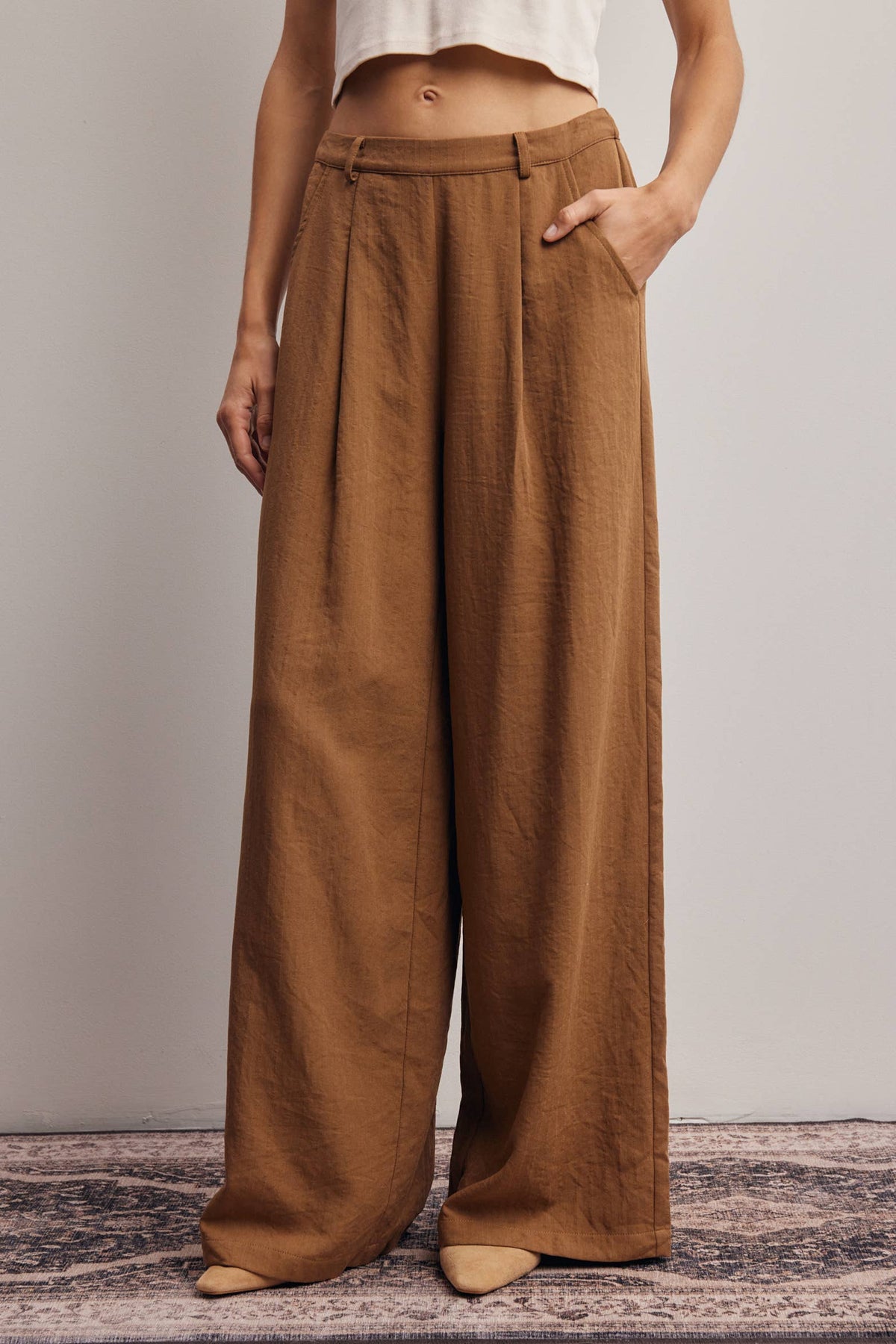 Brown wide-leg pants worn by a person on a neutral background