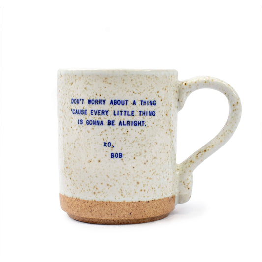 Speckled mug with blue text on a white background