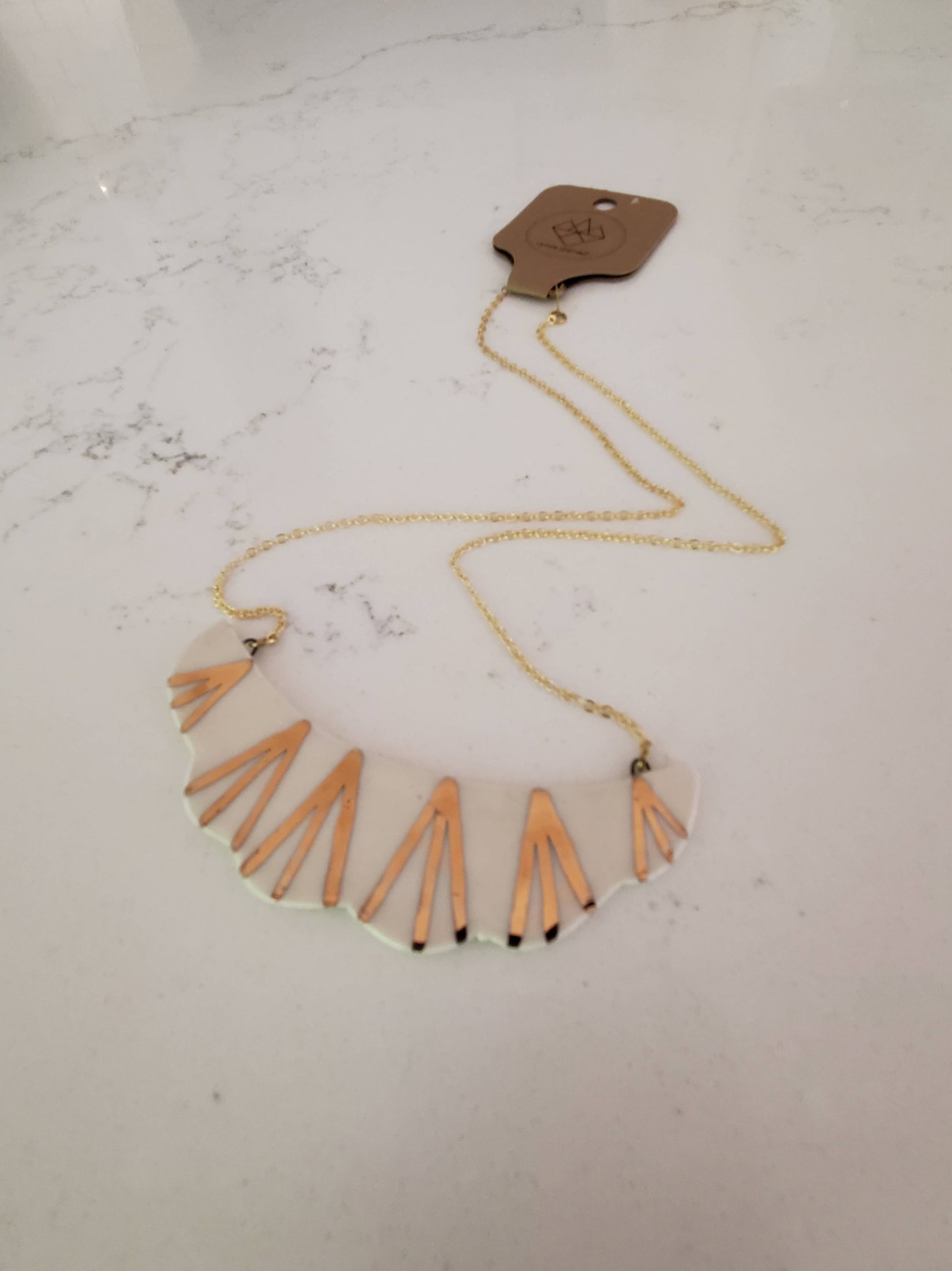 Necklace with orange fringe on a marble surface