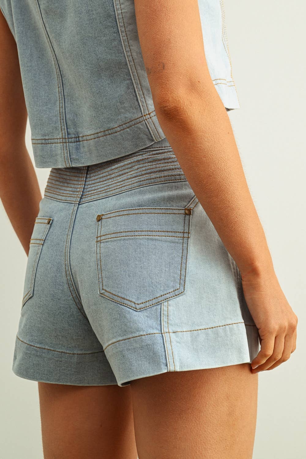 Light blue denim shorts worn by a person on a plain background