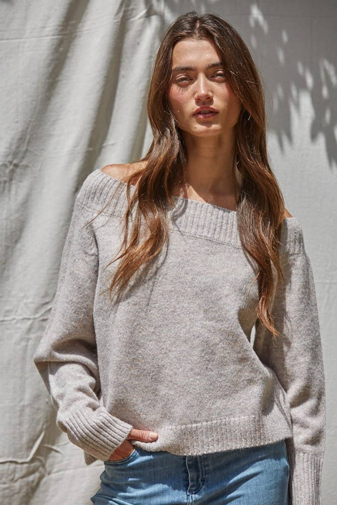 Woman wearing a light gray sweater against a neutral background