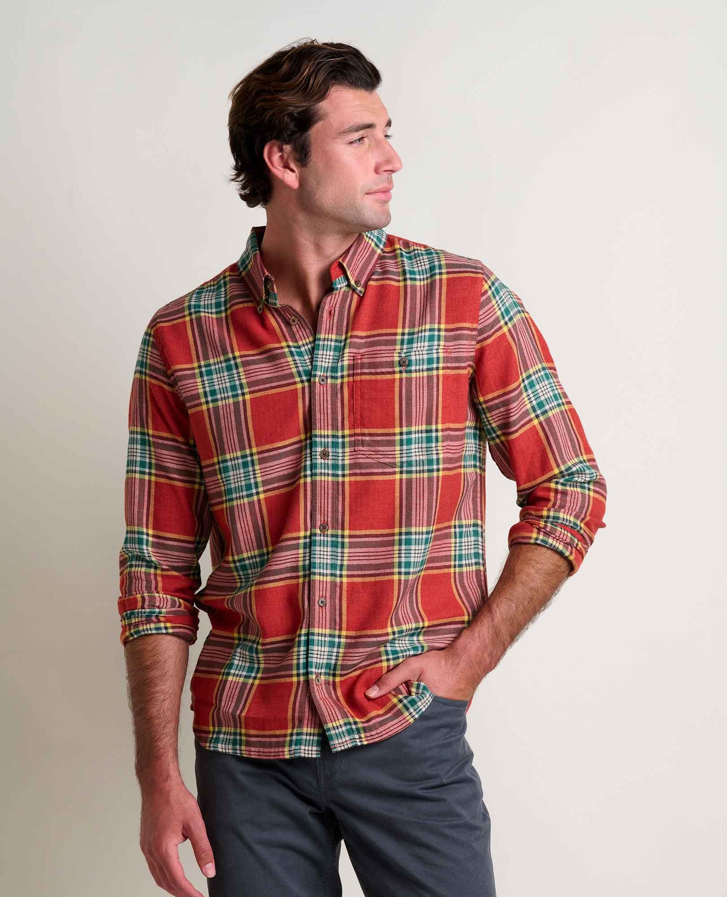 Man wearing a red plaid shirt against a plain background