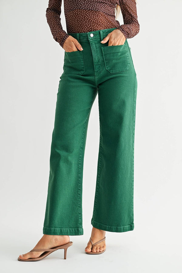 Person wearing green pants and a patterned top on a white background
