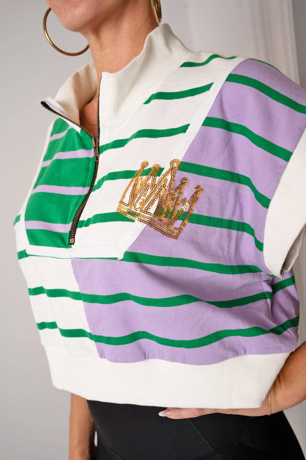 Striped shirt with a gold crown emblem on a gray background