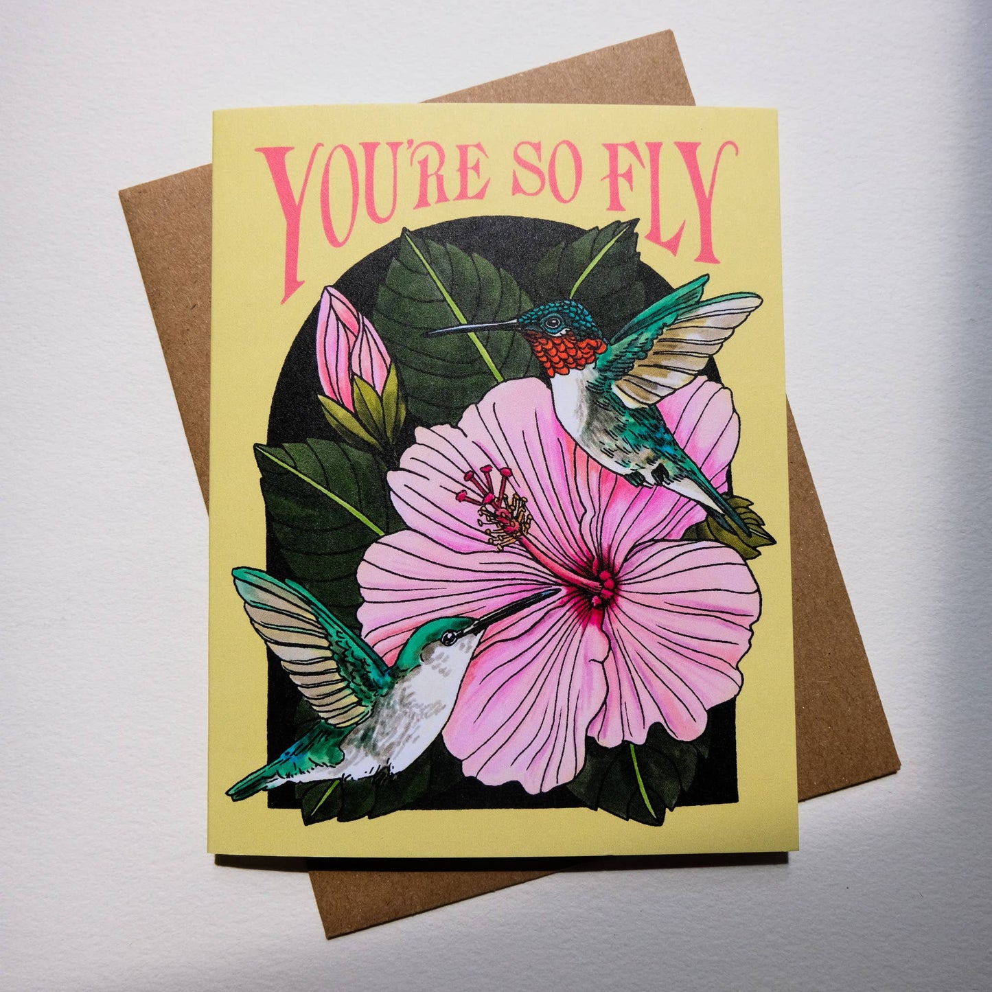 Greeting card with hummingbirds and pink flower design, featuring the text 'You're so fly'.