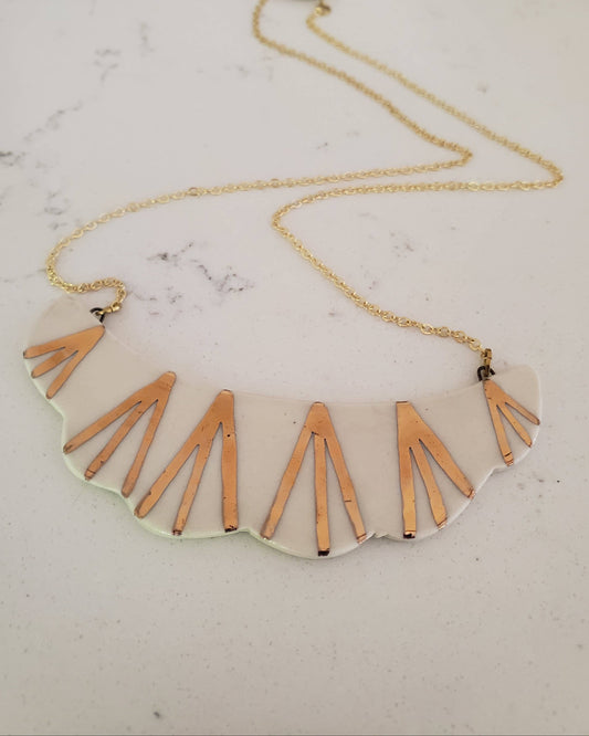 Necklace with geometric pendant on a marble surface