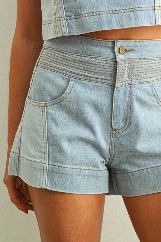 Light blue denim shorts worn by a person on a neutral background
