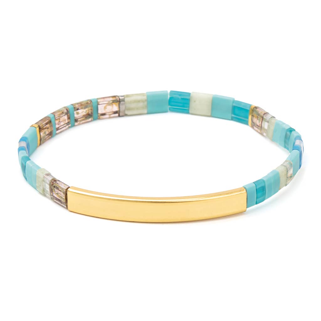 Bracelet with turquoise, beige, and gold accents on a white background