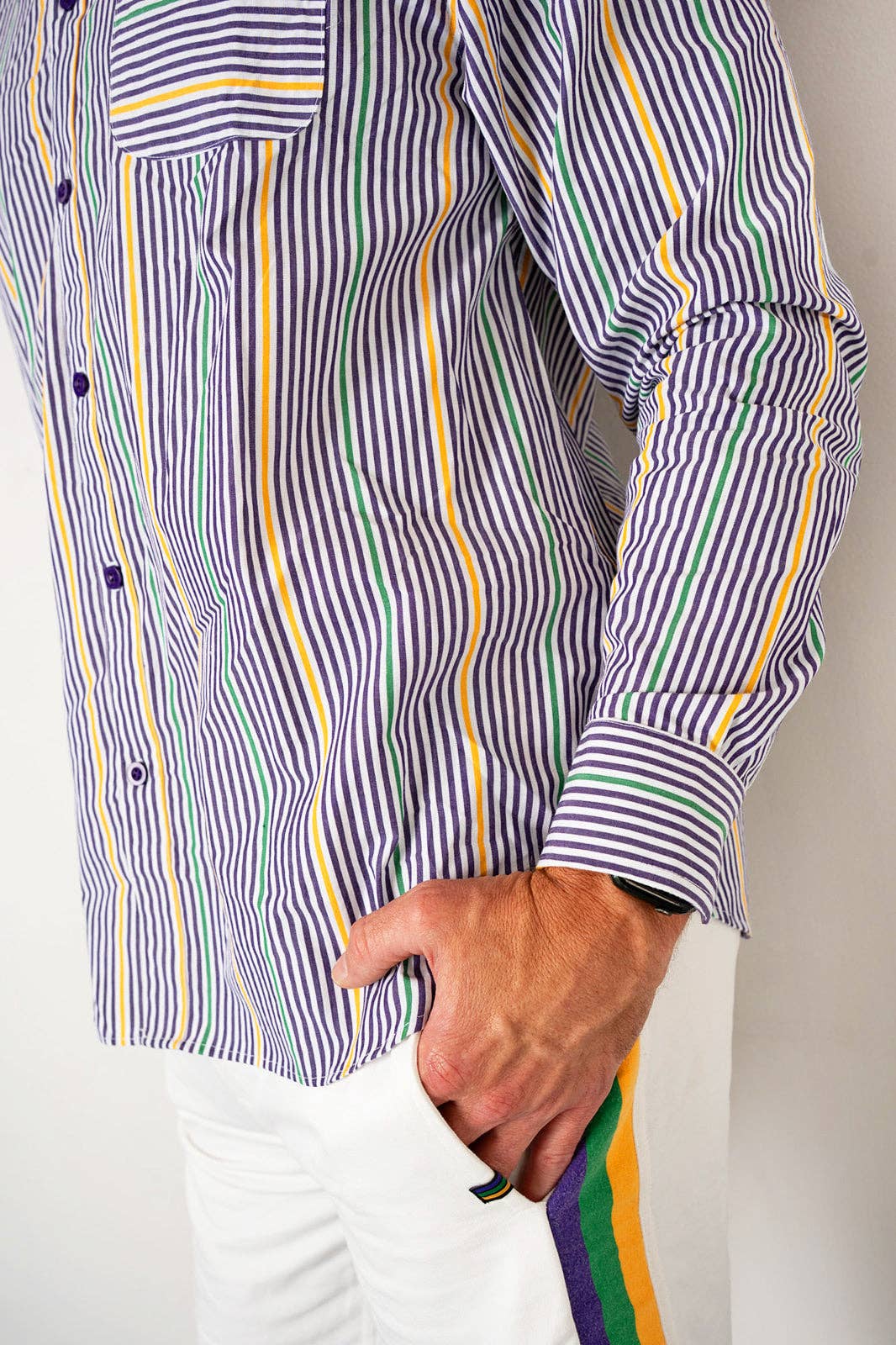 Person wearing a striped shirt with a colorful tie, against a neutral background