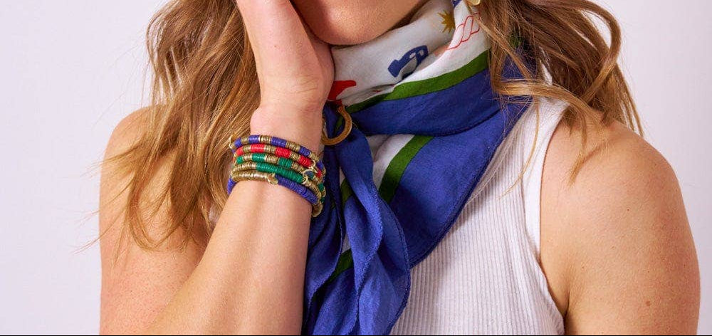 Woman wearing a colorful scarf, earrings, and bracelets on a white background