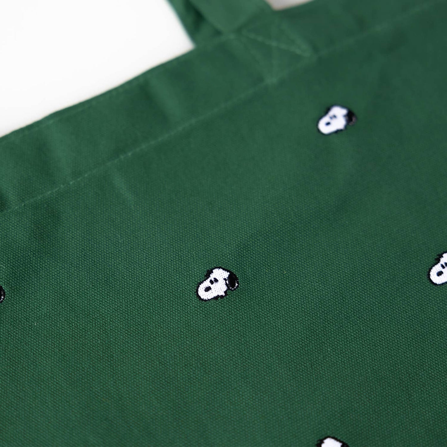 Green fabric with small white and black designs on a white background