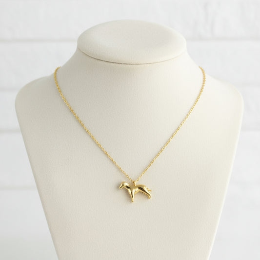 Gold necklace with a dog pendant on a beige card with 'Wearclue' branding.