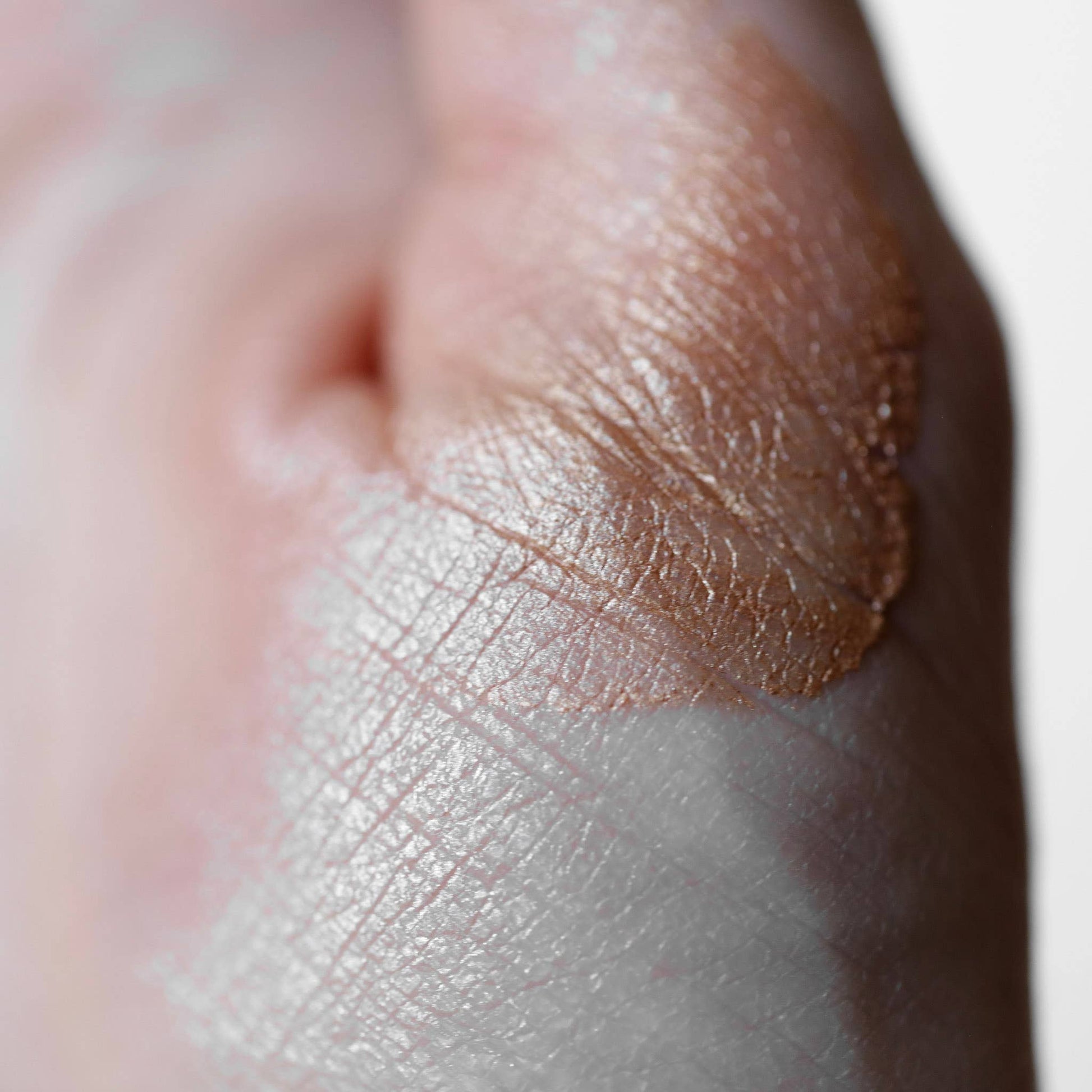 Close-up of a swatch of beige makeup on skin