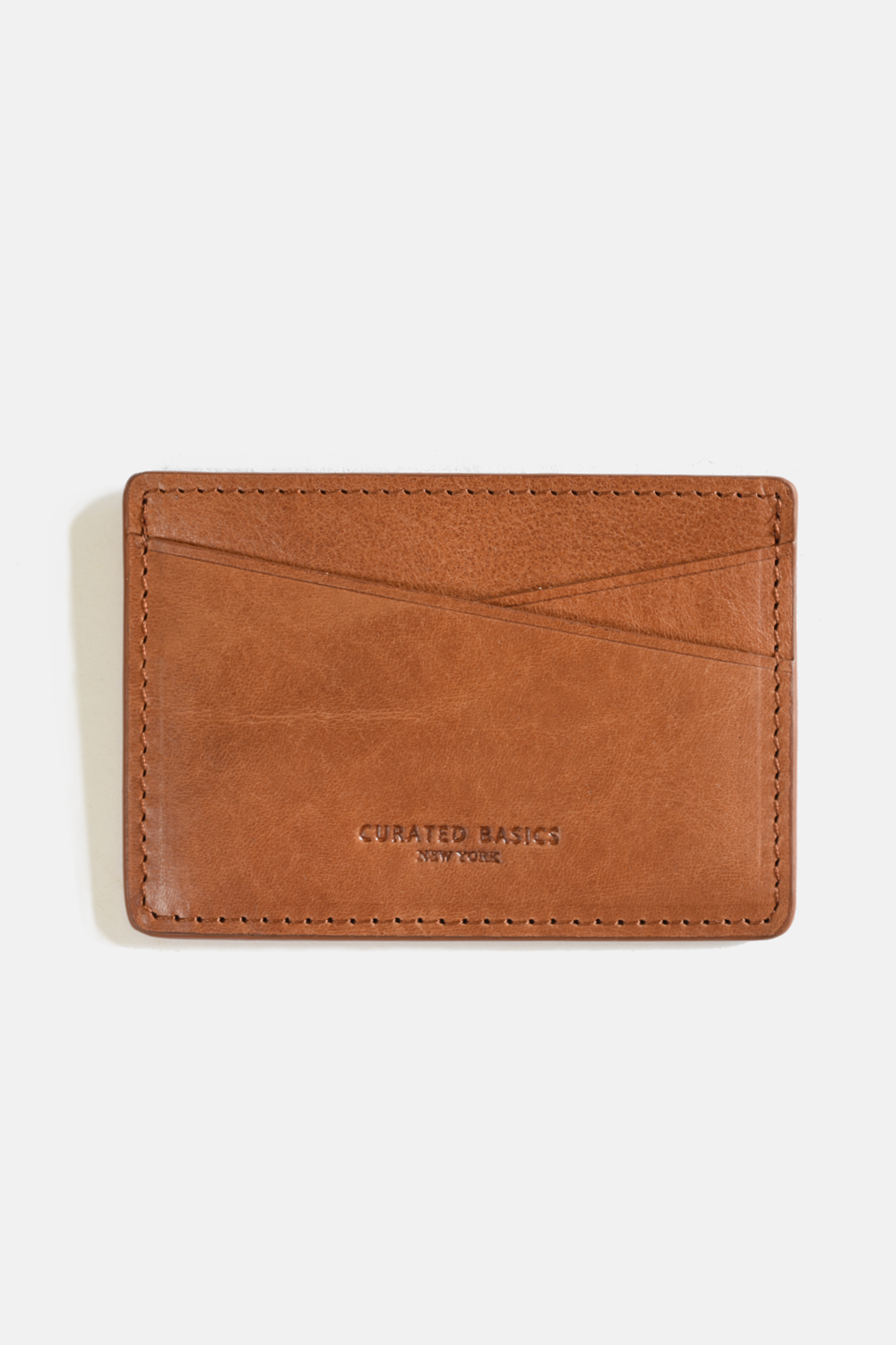 Brown leather cardholder with 'Curated Basics' branding on a white background