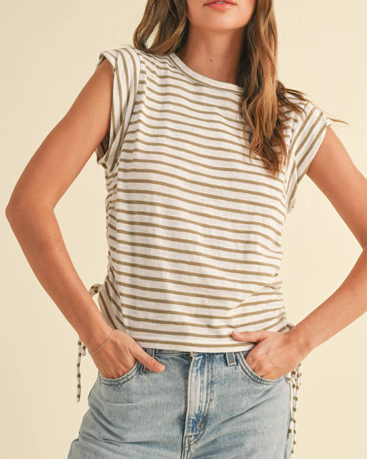 Woman wearing a striped shirt and jeans on a beige background