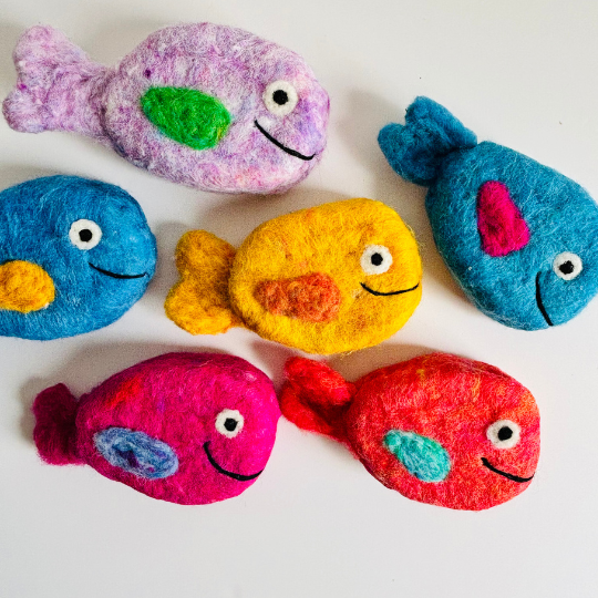 Colorful fish-shaped rocks on a white background