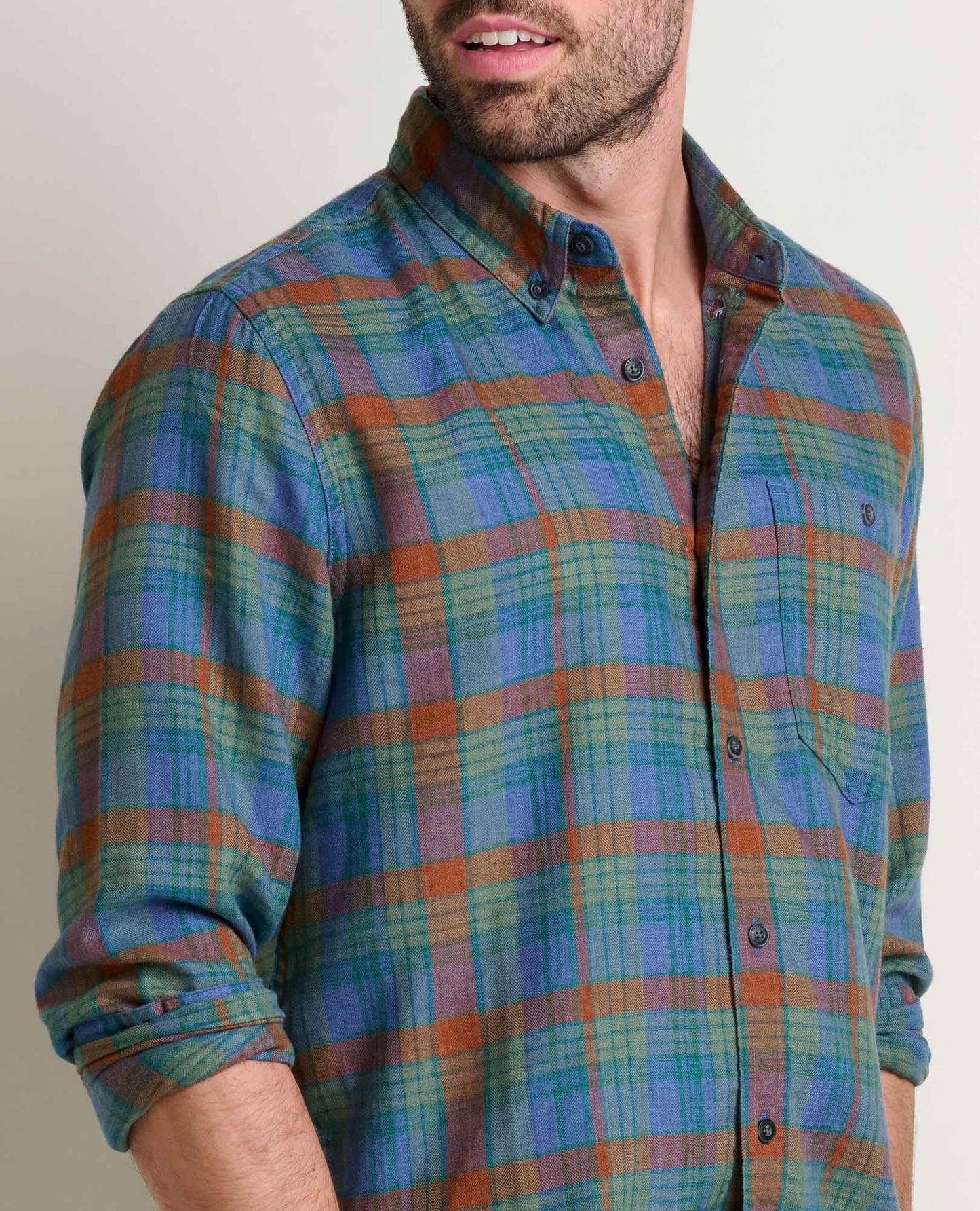 Man wearing a plaid shirt with a neutral background