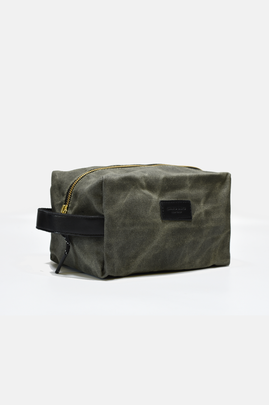 Waxed canvas toiletry bag with black zipper on a white background