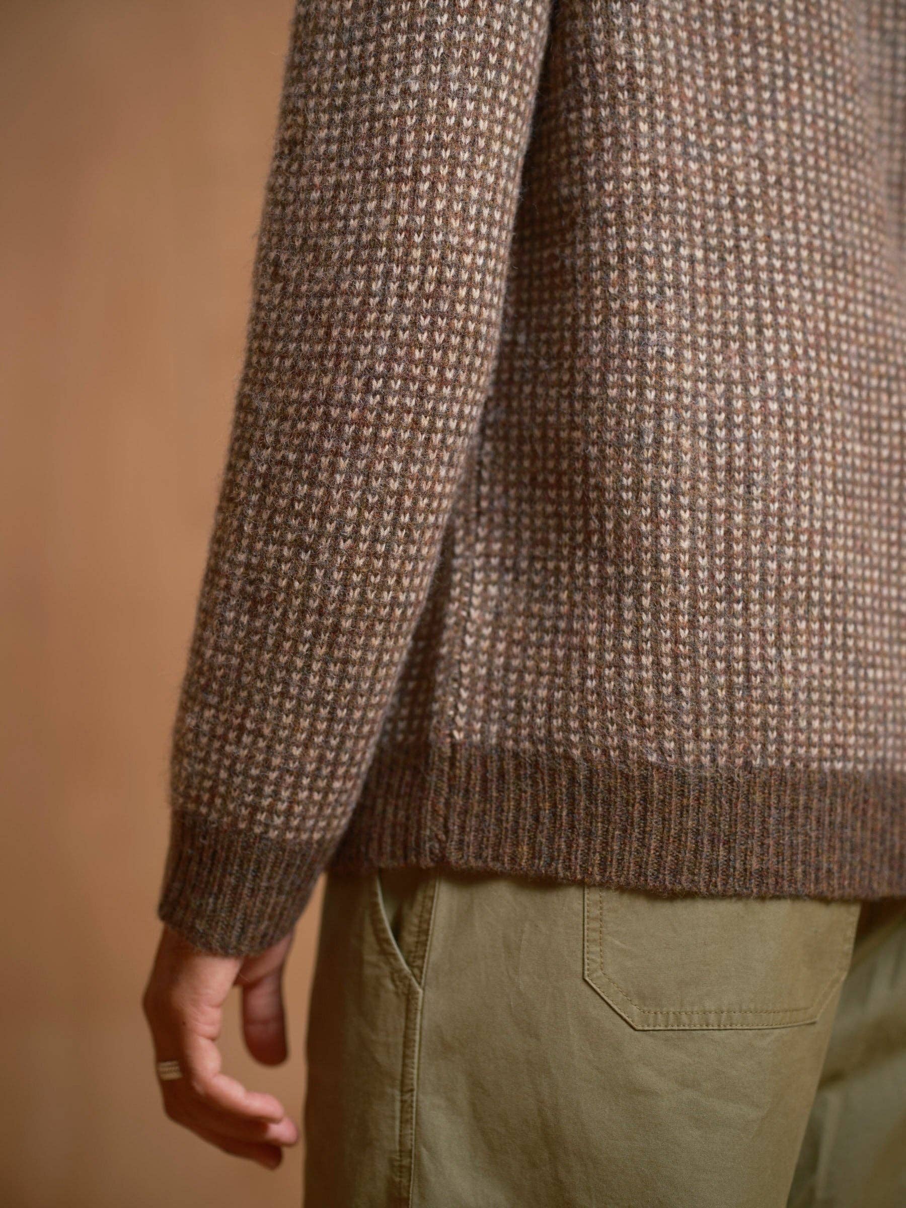 Brown textured sweater worn by a person on a beige background