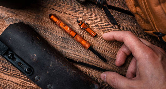 Orange pen and small tool on a wooden surface with 'Lucky Jack' branding.