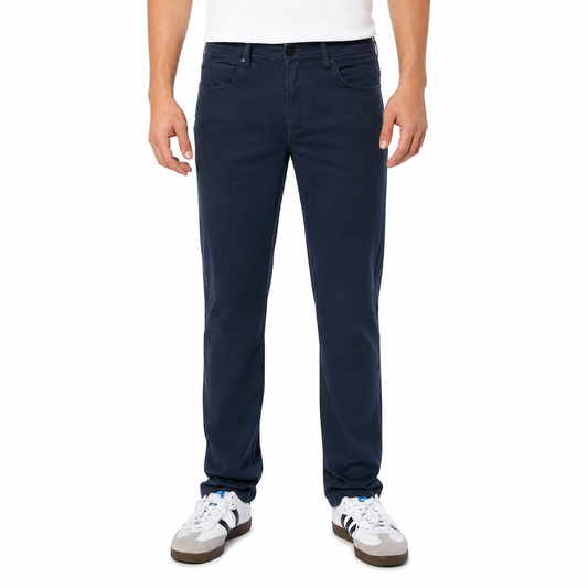 Person wearing navy blue jeans and white sneakers on a white background