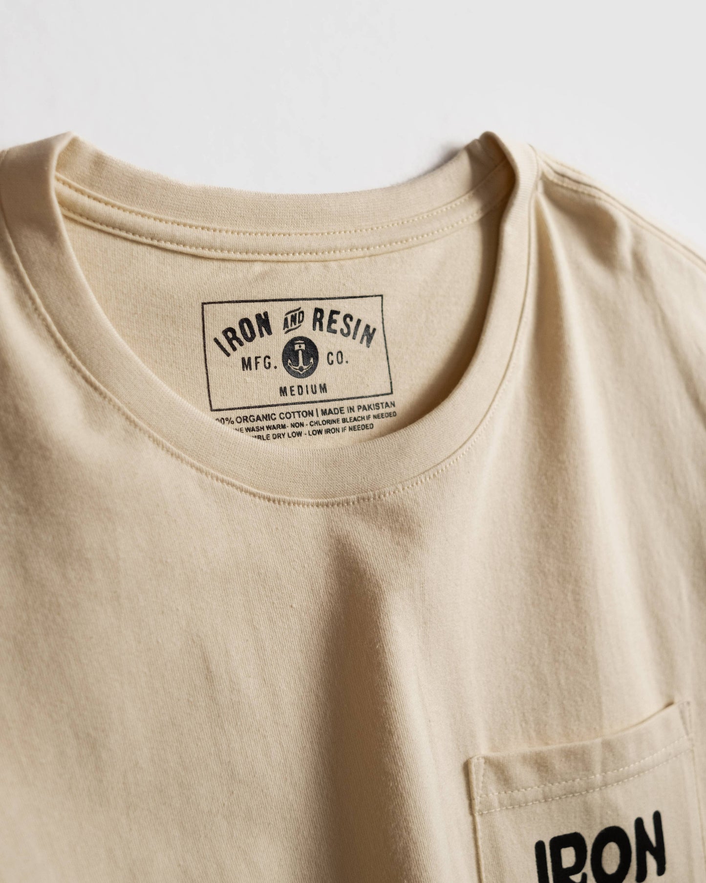 Beige t-shirt with 'Iron & Resin' label on a white background