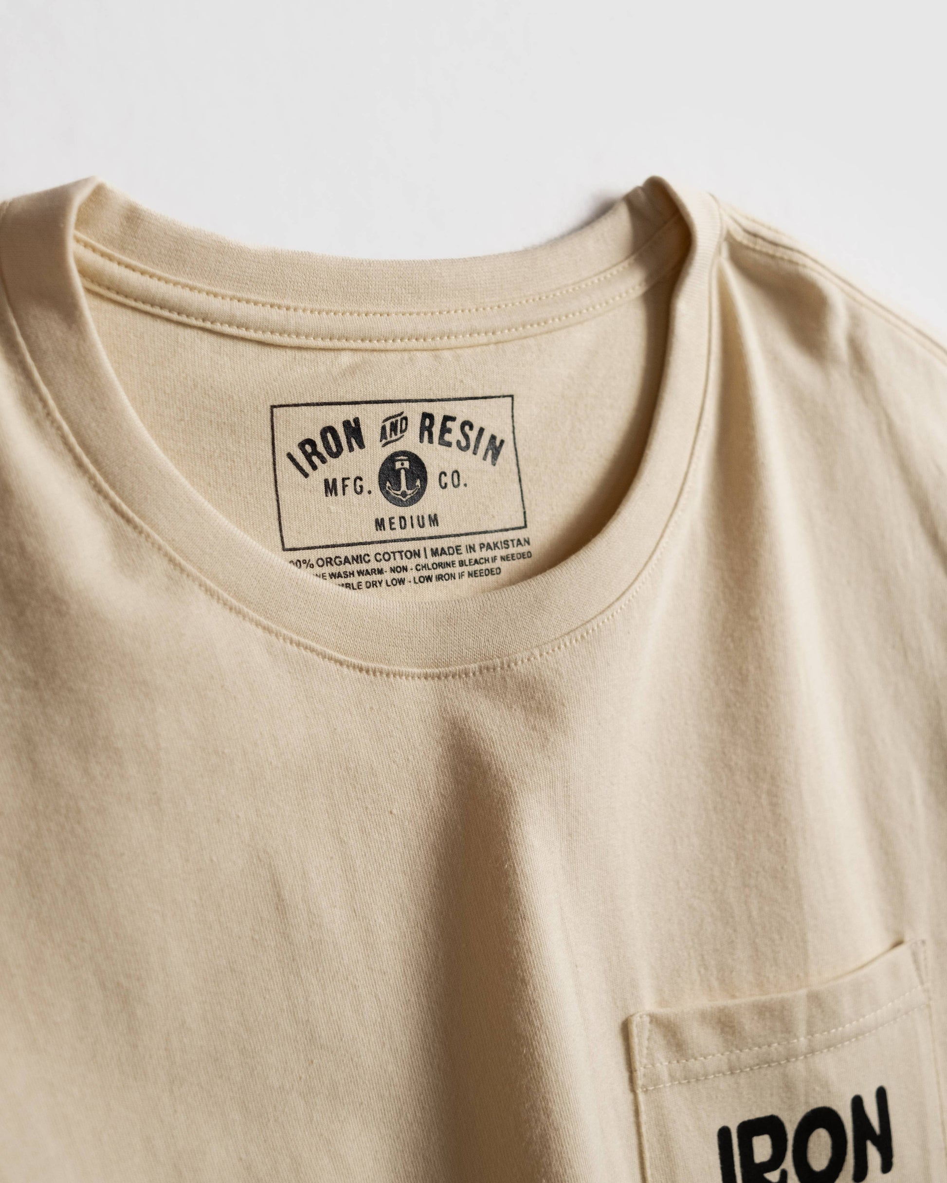 Beige t-shirt with 'Iron & Resin' label on a white background