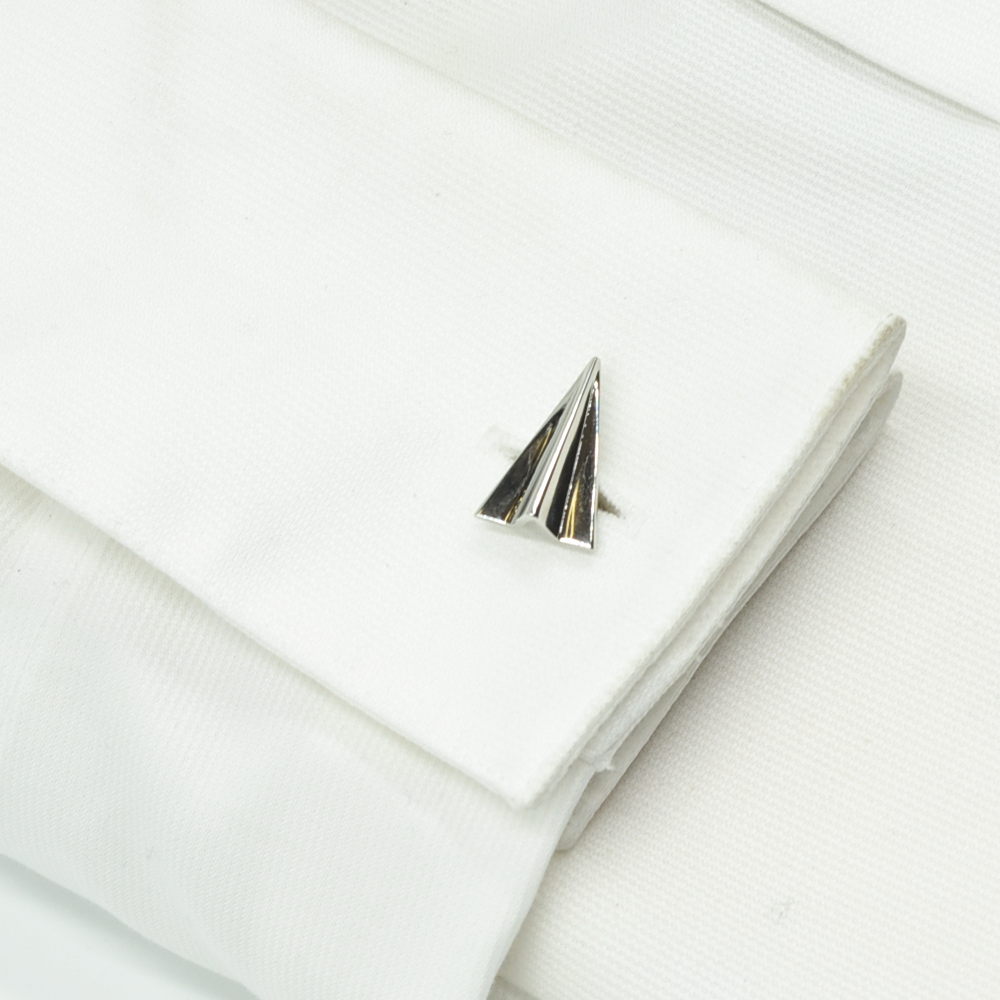 Silver airplane-shaped lapel pin on a white background