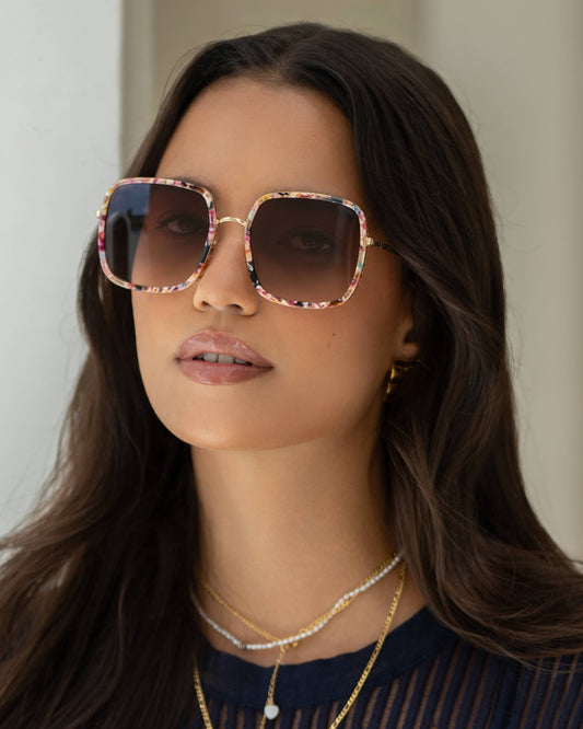 Woman wearing sunglasses with a neutral background