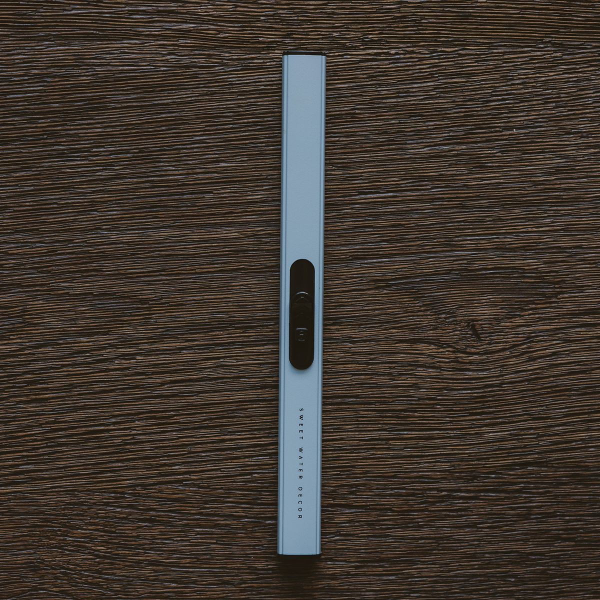 White ruler with black markings on a wooden surface