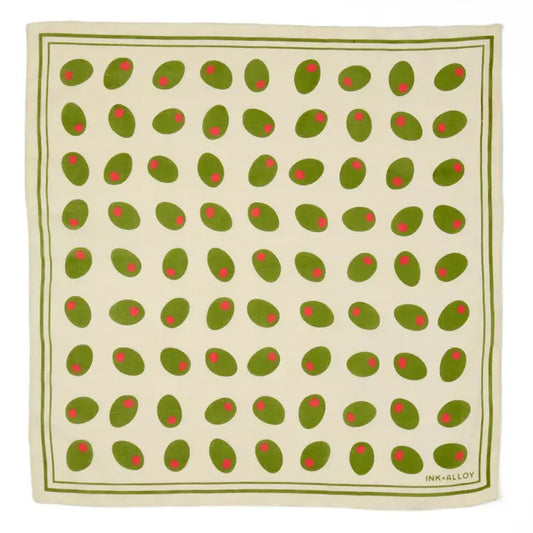 A square scarf featuring a repeating pattern of green olives with red pits on an off-white background, bordered by a green double-line frame. The brand name 'INK & ALLY' is printed in the bottom right corner.