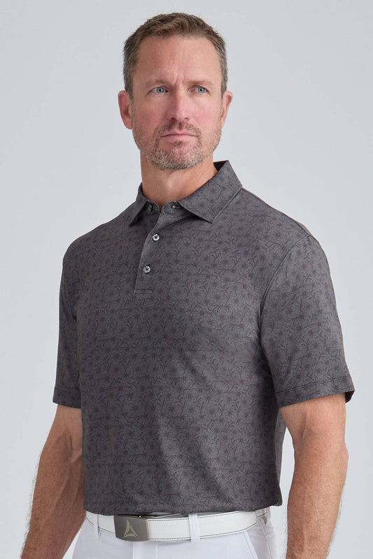 Man wearing a gray patterned polo shirt against a light gray background