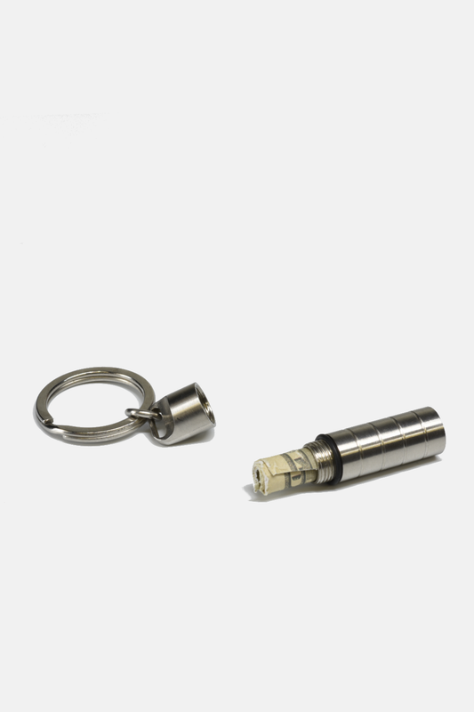 Metal keychain with a cylindrical device on a white background