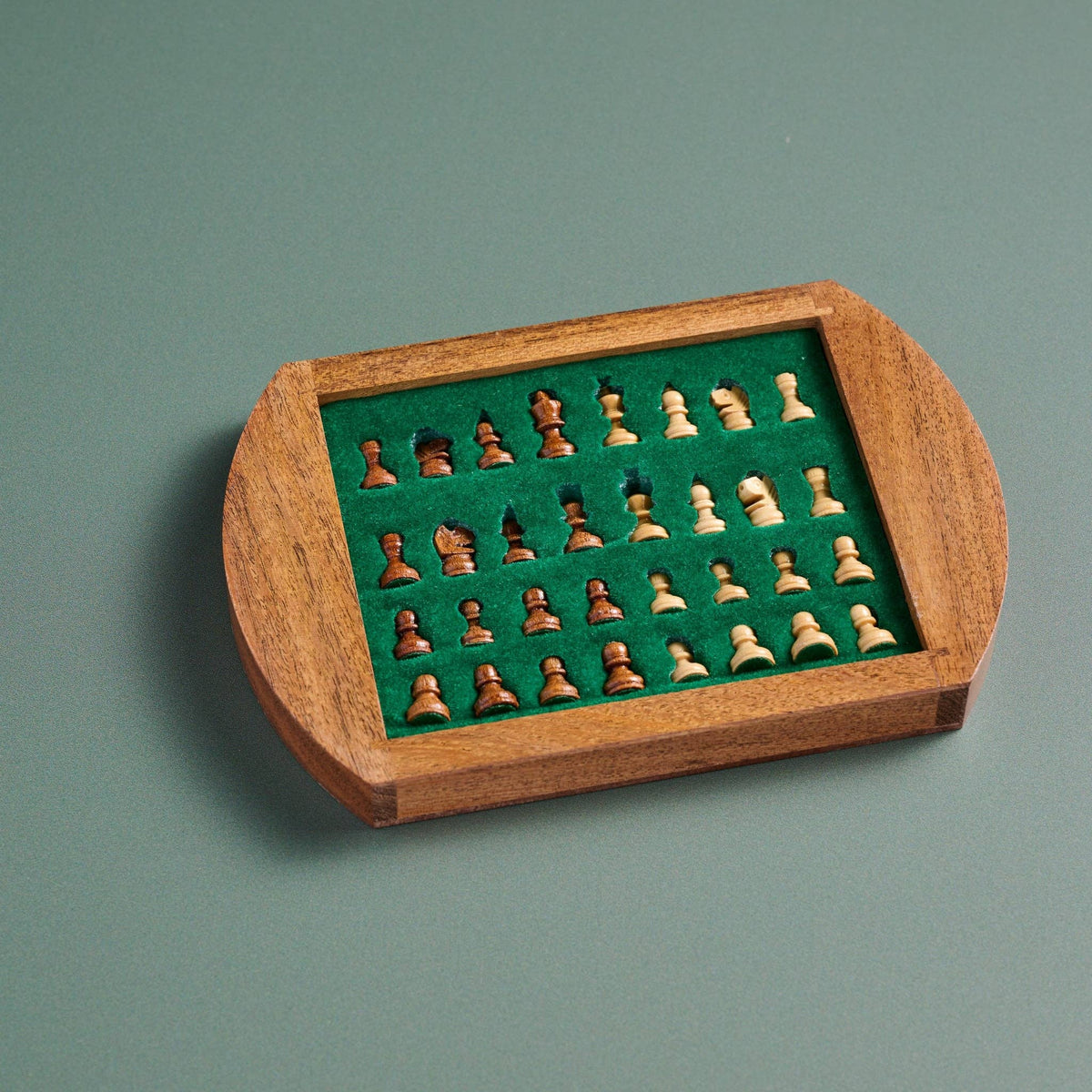 Wooden chess set with pieces on a green felt background