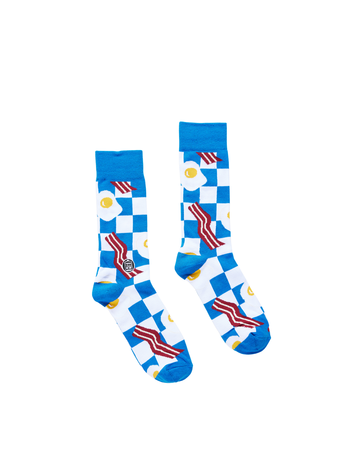 A pair of crew socks with a blue and white checkered pattern, decorated with red and white striped bacon strips, yellow-and-white fried eggs, and small yellow crescent moons, shown on a plain white background.