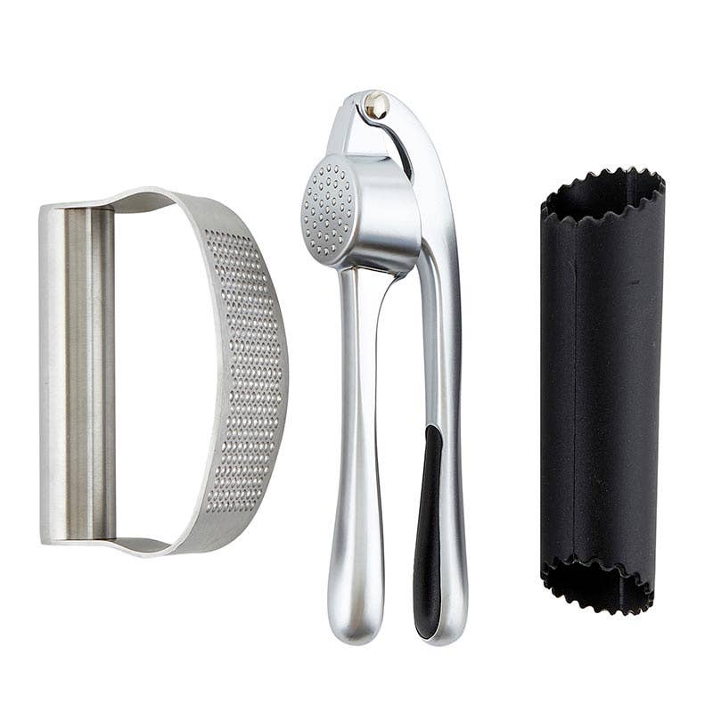 Set of kitchen tools including a metal grater, garlic press, and black container on a white background