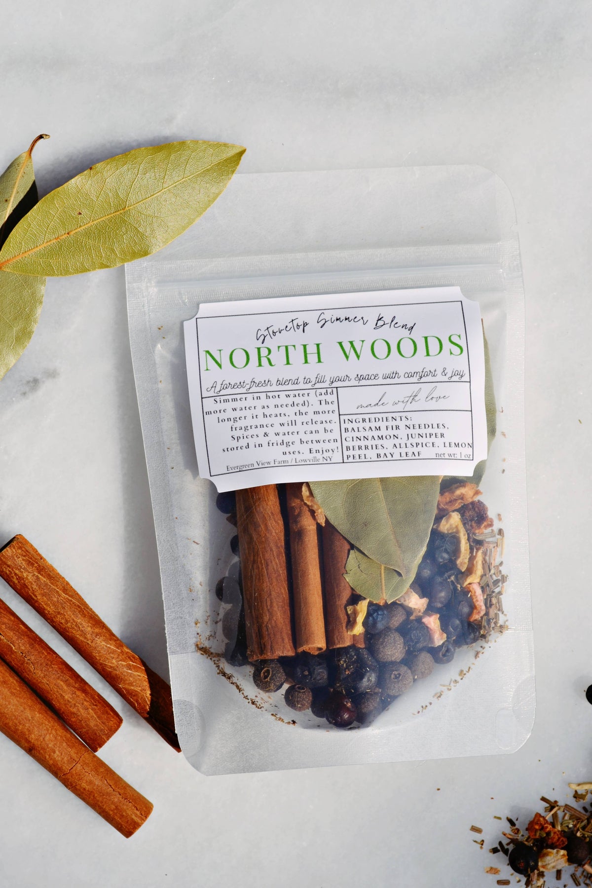 Packaged spice mix labeled 'North Woods' with cinnamon sticks and leaves on a light background