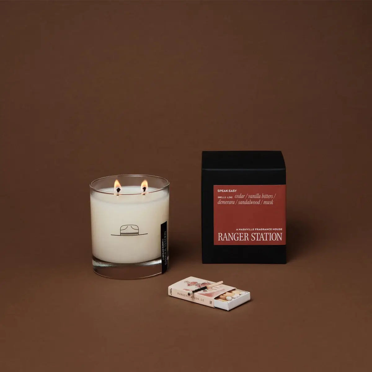Lit candle with a box labeled 'Ranger Station' on a brown background