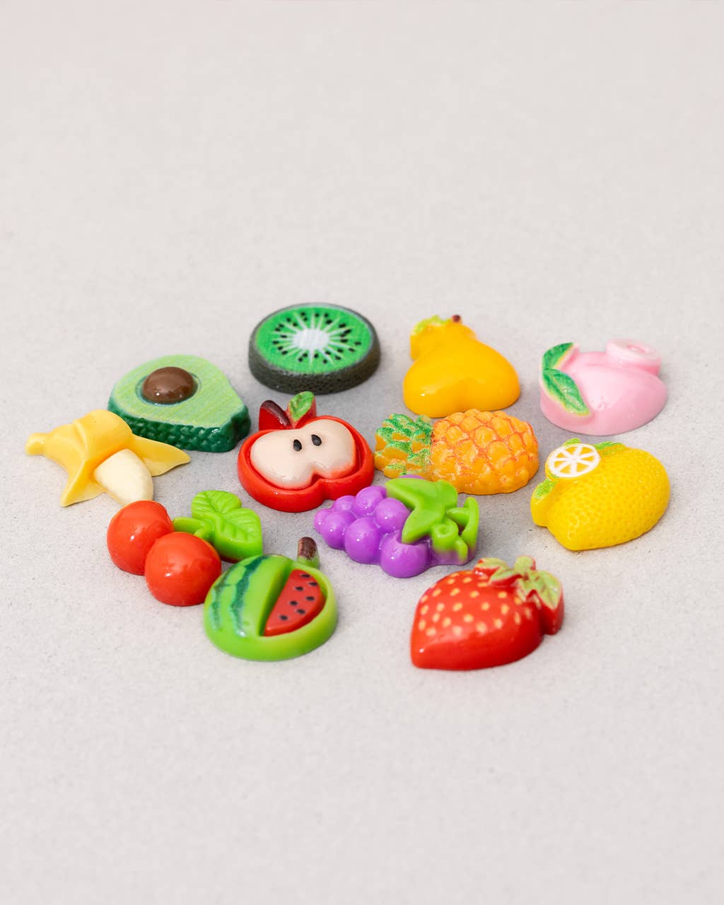 Colorful fruit-shaped erasers on a light gray background