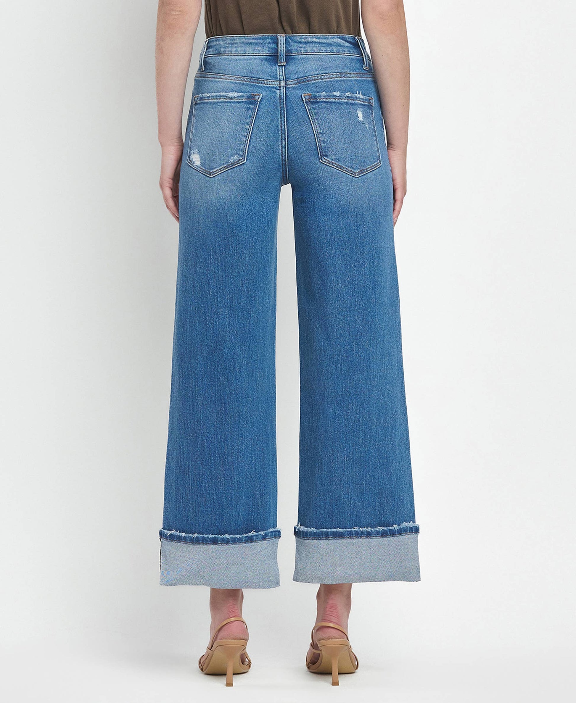 Blue wide-leg jeans worn by a person on a white background