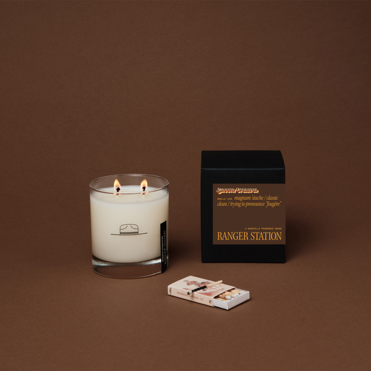 Candle with matches and packaging on a brown background