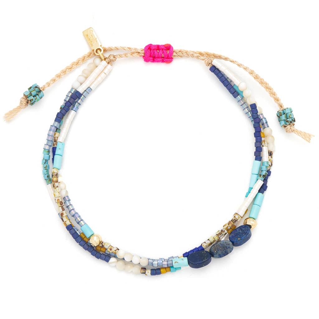 Multistrand beaded bracelet with blue, pink, and gold beads on a white background